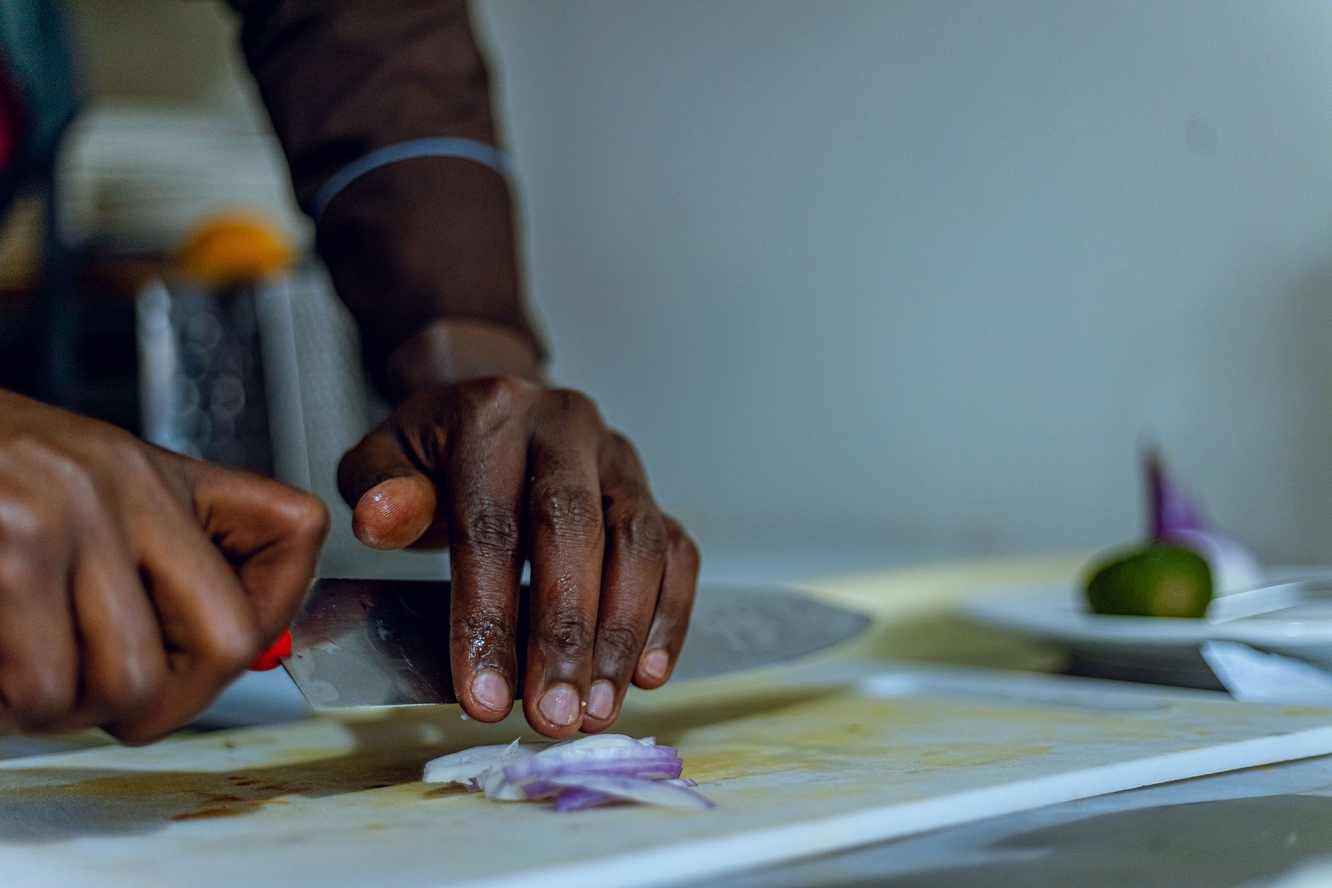A chef slicing onion on a board