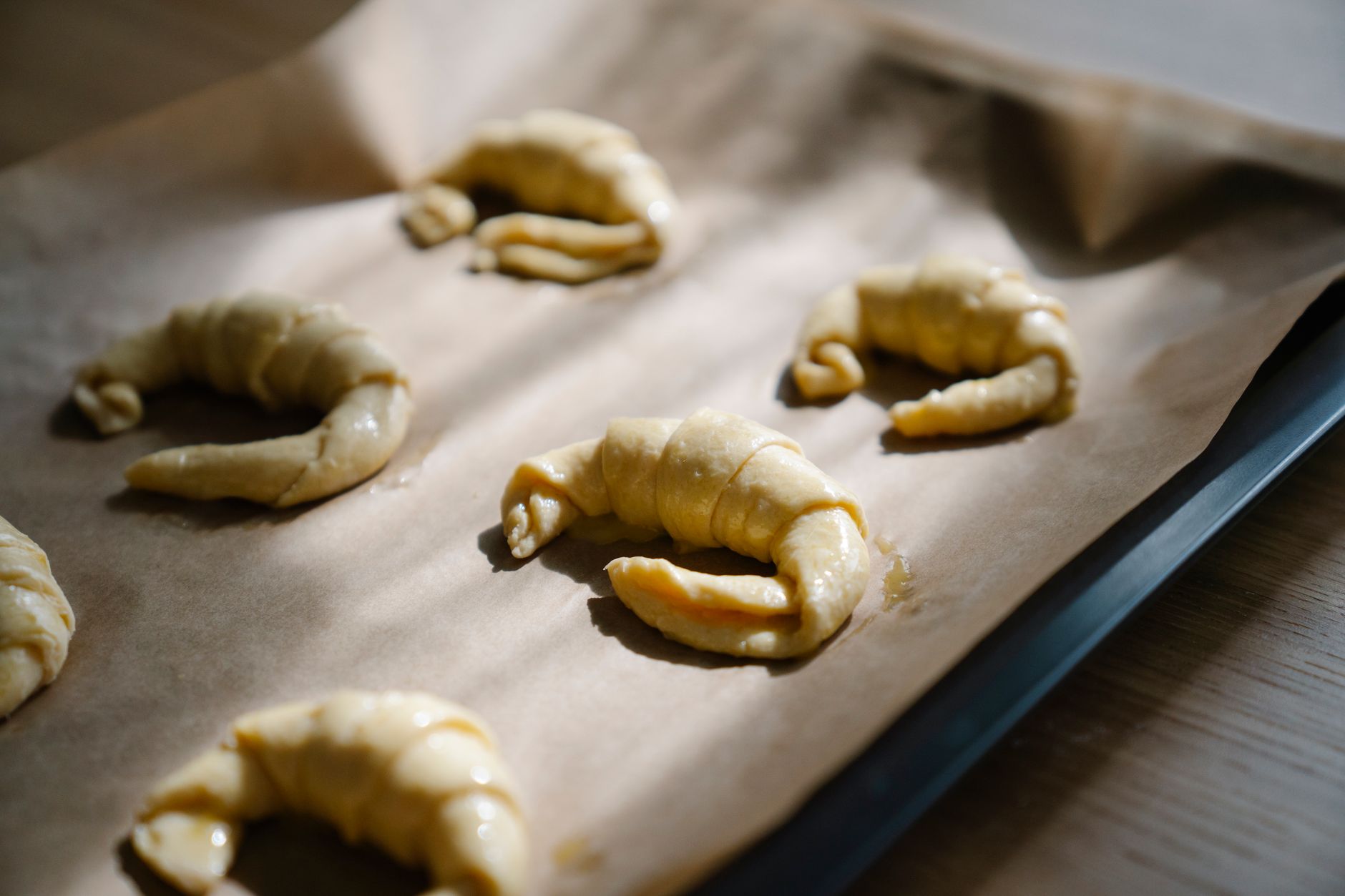 Raw croissants on a baking tray